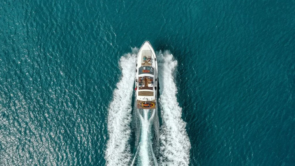 White motor yacht cruising off Mallorca with guests on the bow